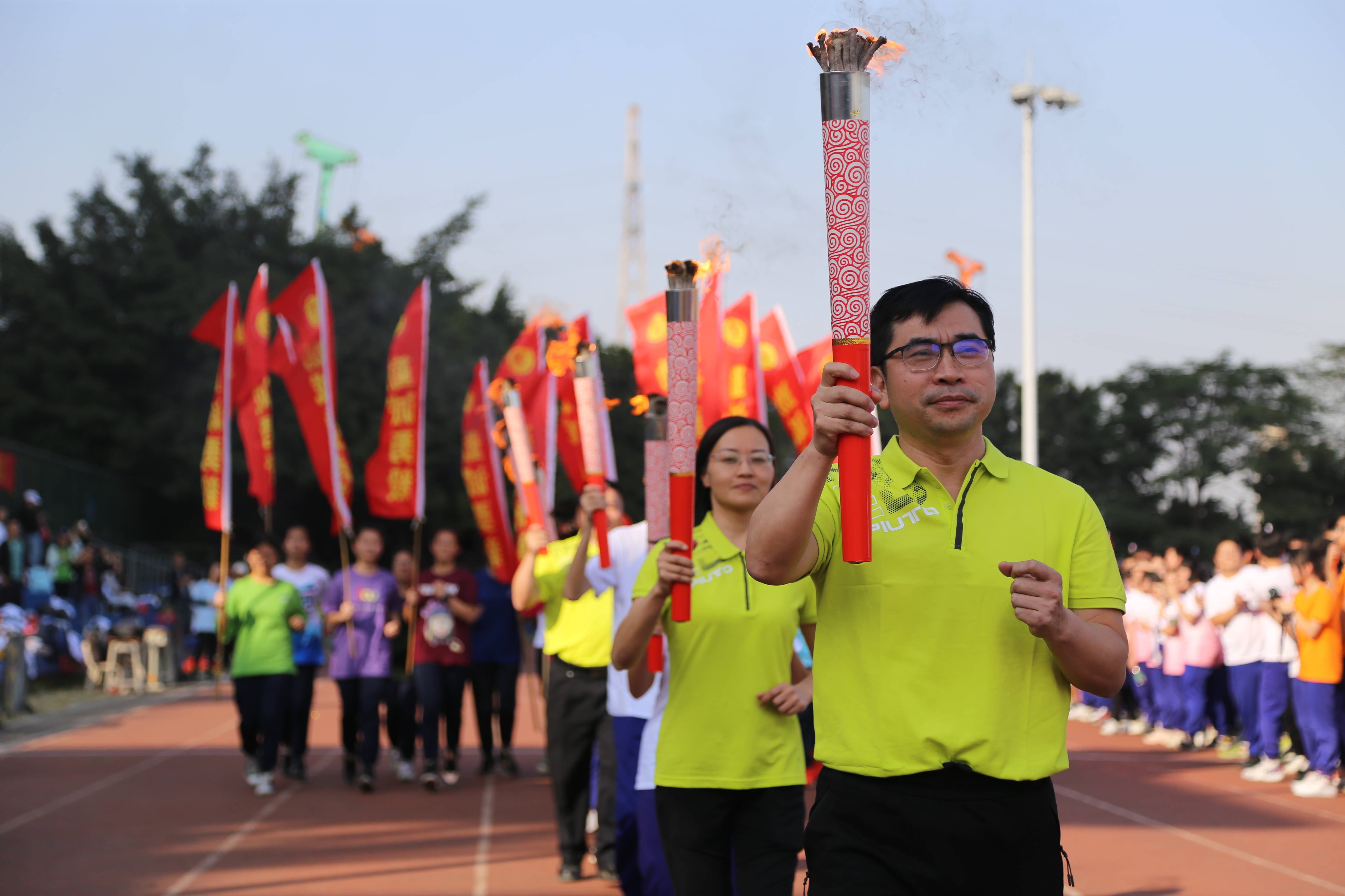 胡革新校长带领优秀教师团队在体育节中点燃火炬前行.JPG